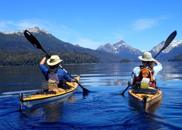 Kayakistas en el lago Nahuel Huapi con los Andes nevados de fondo — actividad acuática en Bariloche