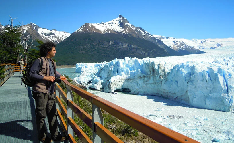 Turista en las pasarelas del Glaciar Perito Moreno contemplando el frente de hielo azul — El Calafate