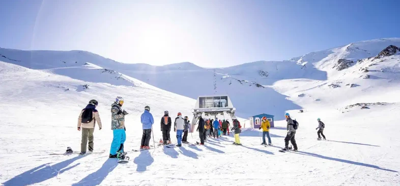 Esquiadores en Cerro La Hoya — pistas y remonte en un día soleado de agosto