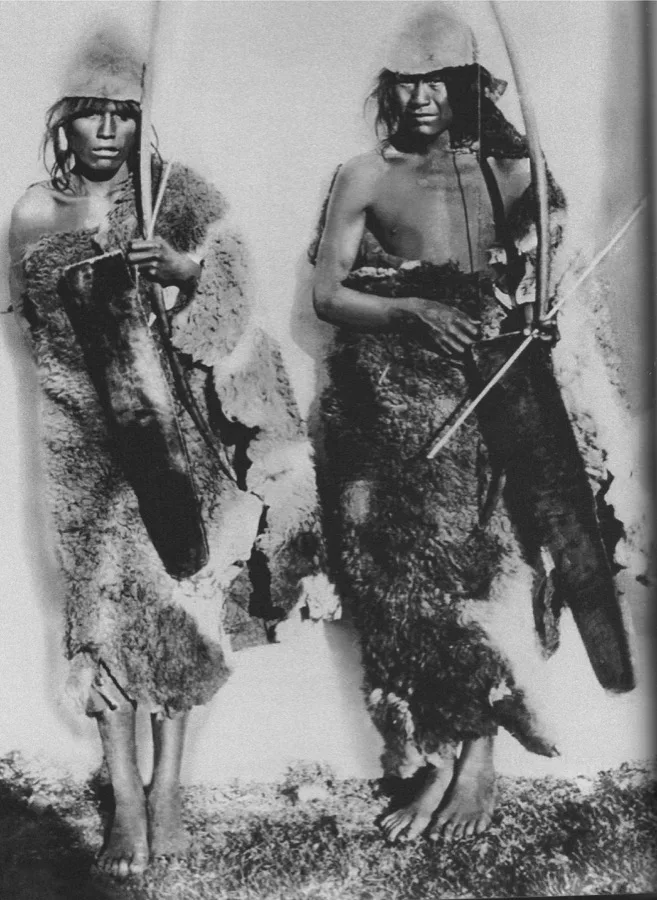 Dos cazadores selknam con capas de guanaco y arcos — retrato etnográfico de Tierra del Fuego