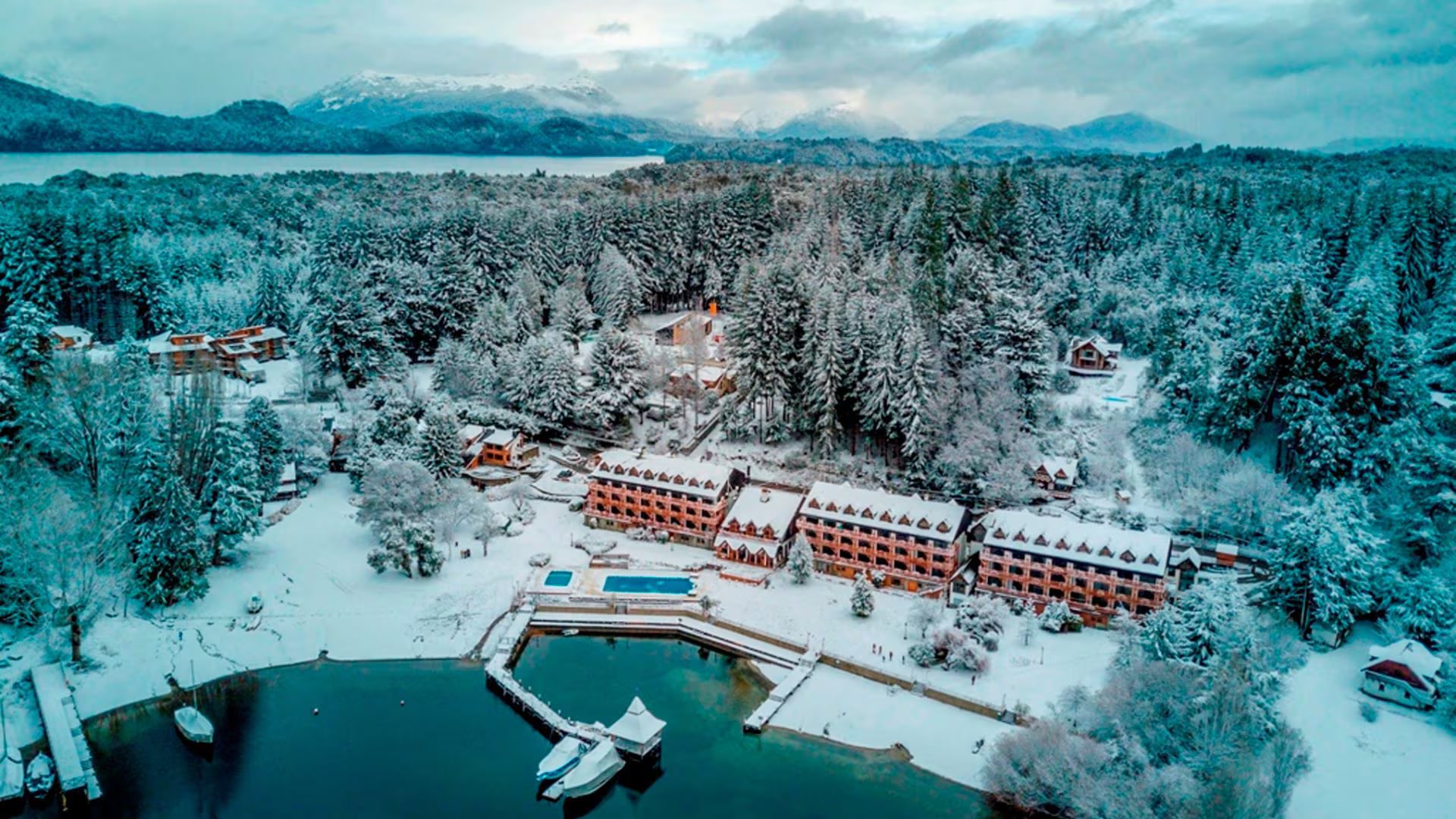 Vista aérea de Villa La Angostura entre bosques nevados y el Lago Nahuel Huapi