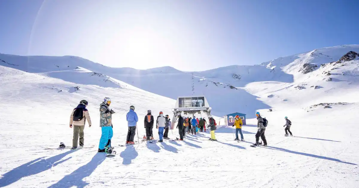 Esquiadores en La Hoya — pistas y remonte en un día soleado de agosto