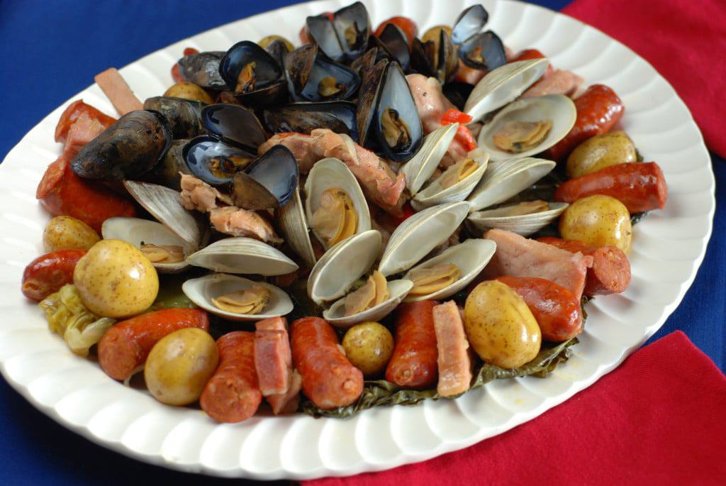 Curanto chileno — mariscos, carnes y papas cocidos bajo tierra con piedras calientes
