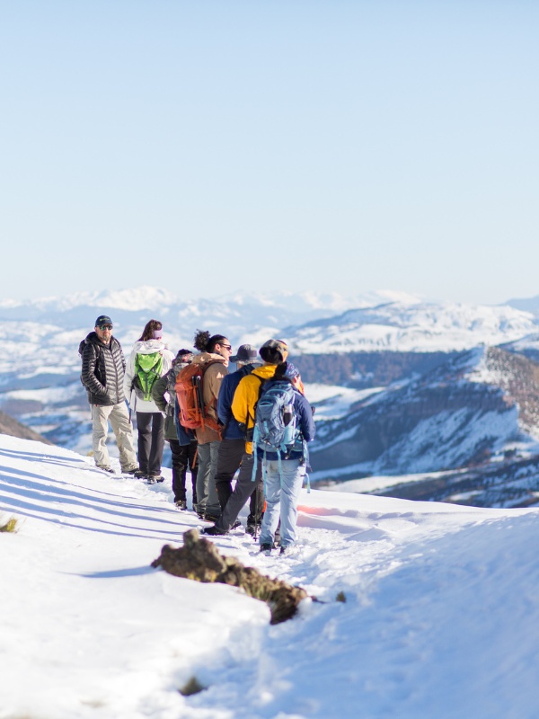 Grupo de trekkers en cima nevada con vistas a los Andes patagónicos
